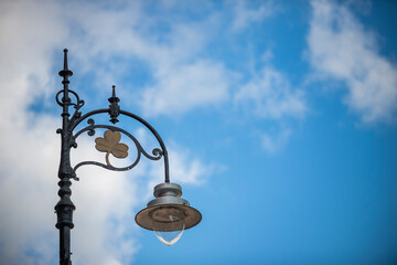 Fototapeta na wymiar Metal lamppost on a Dublin street one day with blue skies without rain
