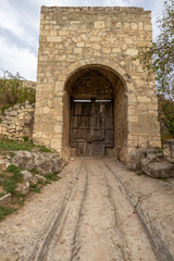 Wooden gate in the tower of an antique stone fortress