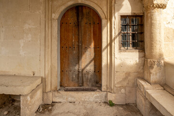 An old wooden door in a stone wall of an ancient building.