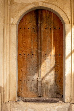 An old wooden door in a stone wall of an ancient building.