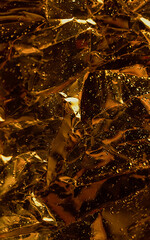 Abstract golden shiny metallic background, decorative yellow glowing texture, brilliant metal surface, art ornamental wallpaper