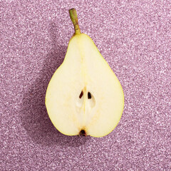 Slit pear on a shiny pink background