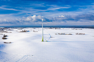 Wind turbine on snowy field. Alternative energy in winter.