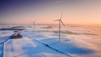 Alternative energy in winter. Wind turbine on winter snowy field.