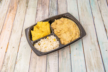 Mexican menu of pumpkin flower chicken stew with tortilla chips and white rice with yellow corn on takeaway tray