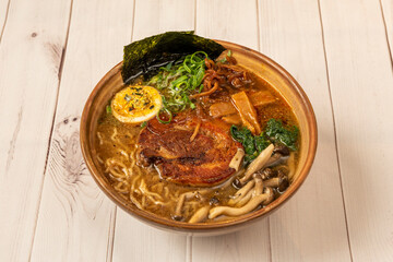 Tokio ramen with meat, noodles, mushrooms and seaweed cooked in a large brown bowl