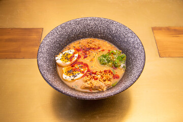 Delicious dish of Japanese ramen with miso, noodles, vegetables, cooked chicken, boiled egg and paprika