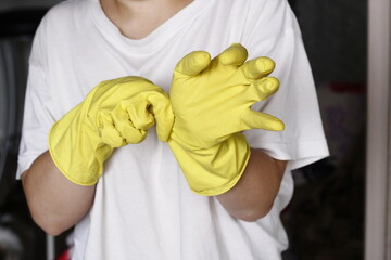 Closeup person cleaning the kitchen yellow gloves housework hands washing hygiene health