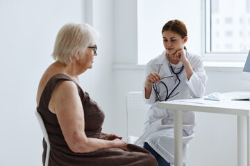 Obraz premium doctors in the medical office talking to an elderly woman health diagnostics