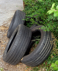 Used tires discarded in alley of residential neighborhood.