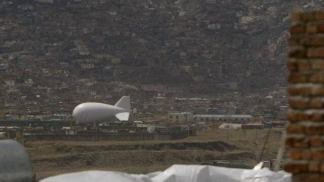 Afghanistan scene - kabul city - hill side settelment and surveillance blimp on the ground