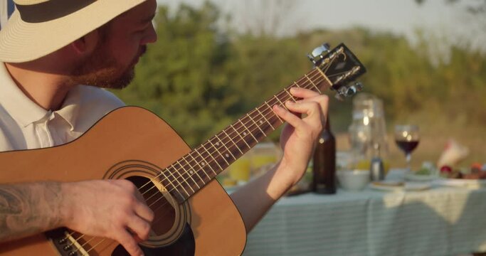 Man playing guitar at barbecue party