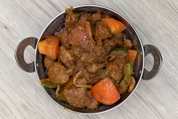 Overhead view of bhuna flavored lamb meat in a bowl from Indian restaurant cooked and seasoned perfectly