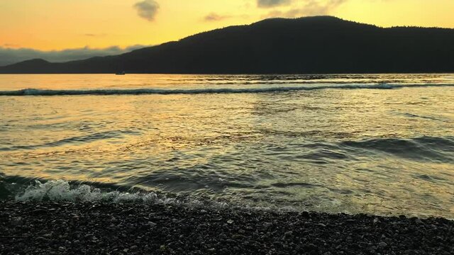 Waves hitting the shore on gravel spit at sunset in Port San Juan, Port Renfrew, British Columbia, Canada