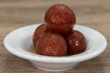 Round gulab jamon spheres stacked neatly for dessert from Indian restaurant cooked and seasoned perfectly