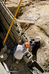 Block masons building a retaining wall