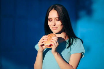 Beautiful Young Woman Holding a Delicious Burger