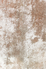 Deteriorated painted cement wall with some orange lichen on the surface.
