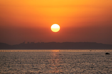 The sea under the setting sun is golden, and the sun is like an egg yolk