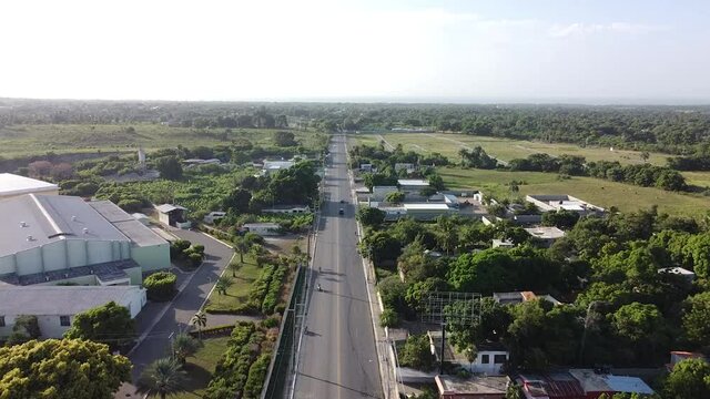 toma estatica de dron sobrevolando carretera larga con poco trafico al lado de la carretera, ambiente rural