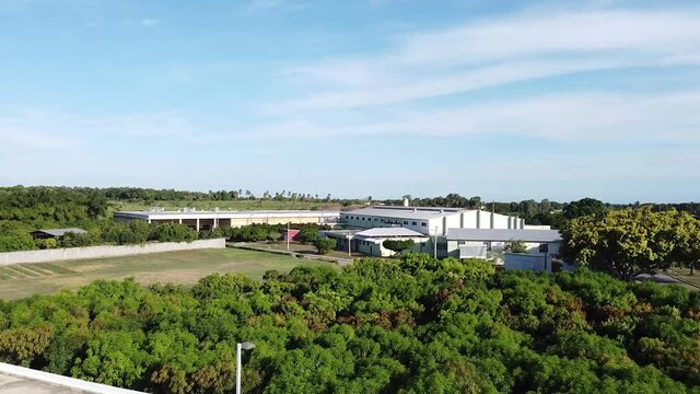  escena de un dron est&aacute;tico movi&eacute;ndose hacia una f&aacute;brica industrial en el campo mientras el dron avanza, concepto de empresas industriales fuera de la ciudad