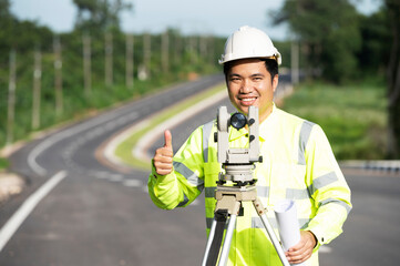 Asian engineers use theodolite with equipment at the road construction site before delivering the...