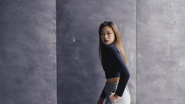 4k slow motion of young asian woman dancing against gray wall young people street dance youth culture