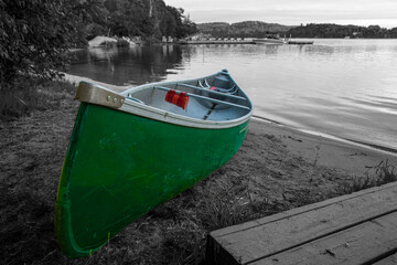 A canoe rests on the sand by a lake in the cottage country of Muskoka in Ontario, Canada.