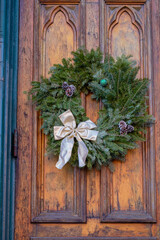Fototapeta na wymiar Yellow church door prepared for the holidays with live wreaths