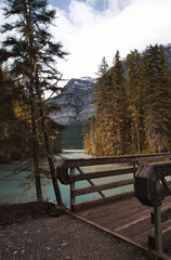 A wooden bridge leads to Lake Kinney with majestic mountains in the background