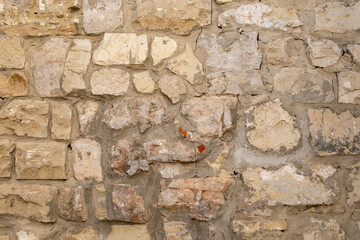 Close-up of a fragment of an old natural white limestone wall.