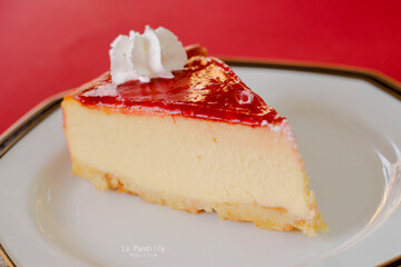 Pequeño pastel de queso de fresa en un plato blanco elegante, aperitivos para celebraciones especiales.