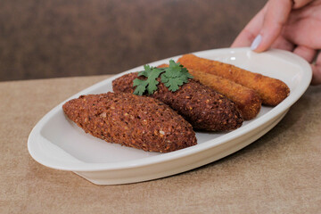 Un joven sirve en la mesa un plato del tradicional aperitivo árabe, conocido en Brasil como Quipe.