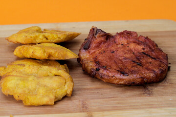 tostones con chuleta cocida sobre mesa de madera, concepto de comida a la parrilla y barbacoa. 