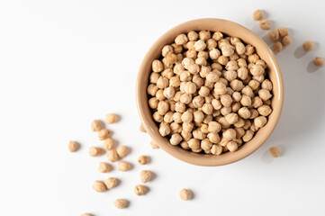 dry chickpeas, in a ceramic dish on a white table, top view, close-up
