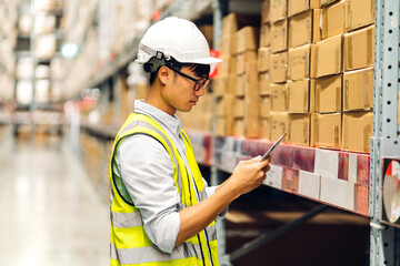 Portrait of smiling asian engineer man order details checking goods and supplies on shelves with goods background in warehouse.logistic and business export