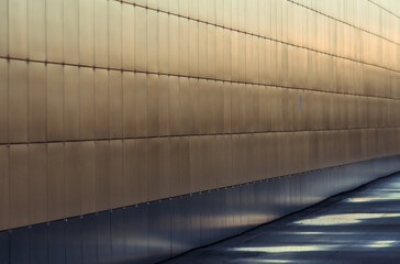 A wall of flat slabs with a brilliant bronze sheen looking into perspective