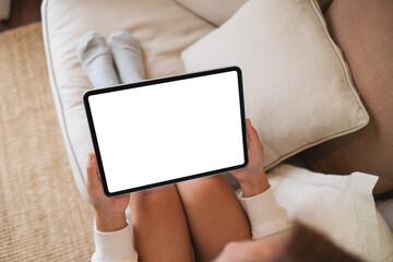 Top view mockup image of a woman holding digital tablet with blank desktop screen on sofa at home