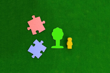 Two pieces of puzzles, a tree, a silhouette of a yellow man on a green background. Creating a new project, implementing business ideas.