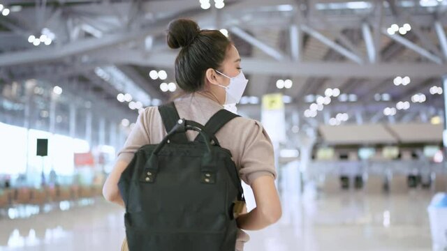 follow shot asian female woman wearing face mask with background walking along with happiness cheerful enjoy trip vacation travel at airport terminal,asian female traveller ready to go abroad concept