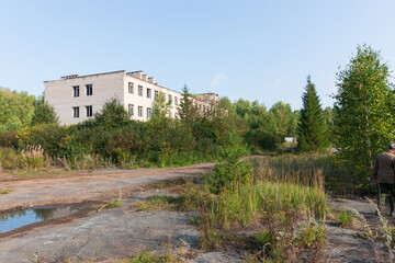 Fototapeta na wymiar abandoned and overgrown territory with asphalt