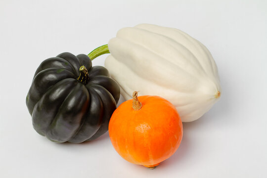 Three pumpkins white and dark green and orange on a light background. Food photo.