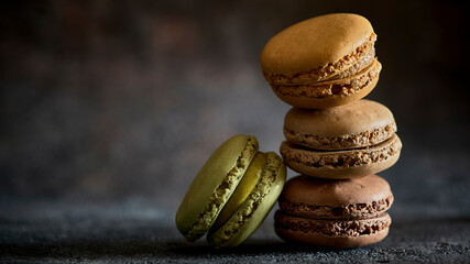 Macarons stacked in a stack on a dark background