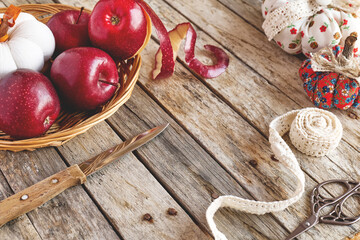 Cozy pumpkins. Autumn decoration with handmade colorful fabric pumpkins and red apples on white wooden background. Fall vibes. Thanksgiving decor.