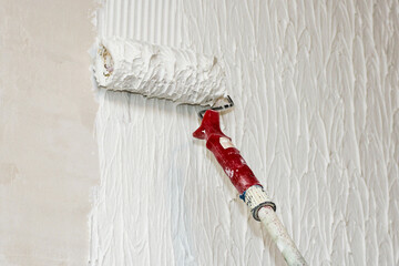 Making decorative plaster with a paint roller.