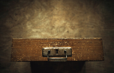 An antique wooden desk drawer on an artistically blurred background. Storage of archival documents.