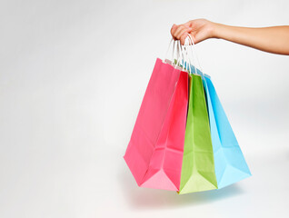 Woman hand with shopping bags on white background