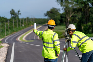 Teamwork of surveyor engineers worker making measuring with theodolite on road works. survey...