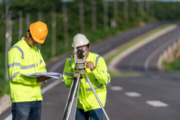 Two surveyor engineers with equipment on road construction site, Civil Engineers, Surveyor...