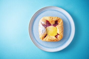 Vanilla cream raspberry jam sweet bun in a plate
